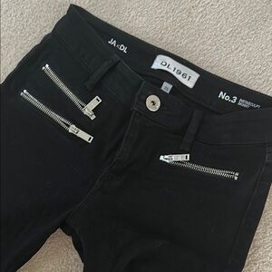 Black skinny jeans with zipper and ripped knees.